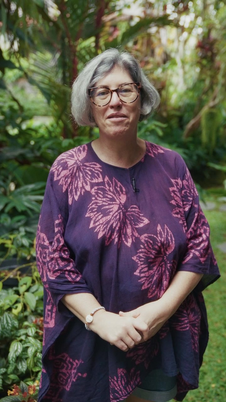 Une femme en robe violette parmi les plantes