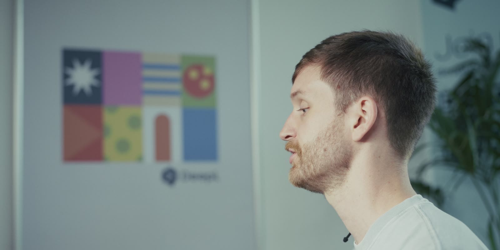 Un ingénieur de profil devant une affiche DeepL