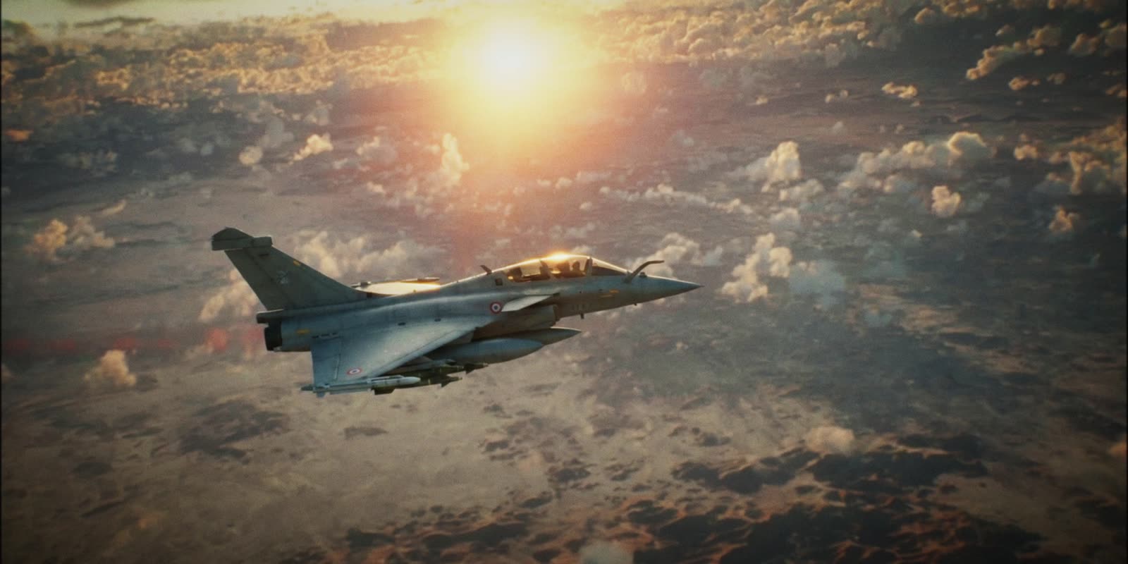 Un avion de chasse au-dessus des nuages au coucher du soleil